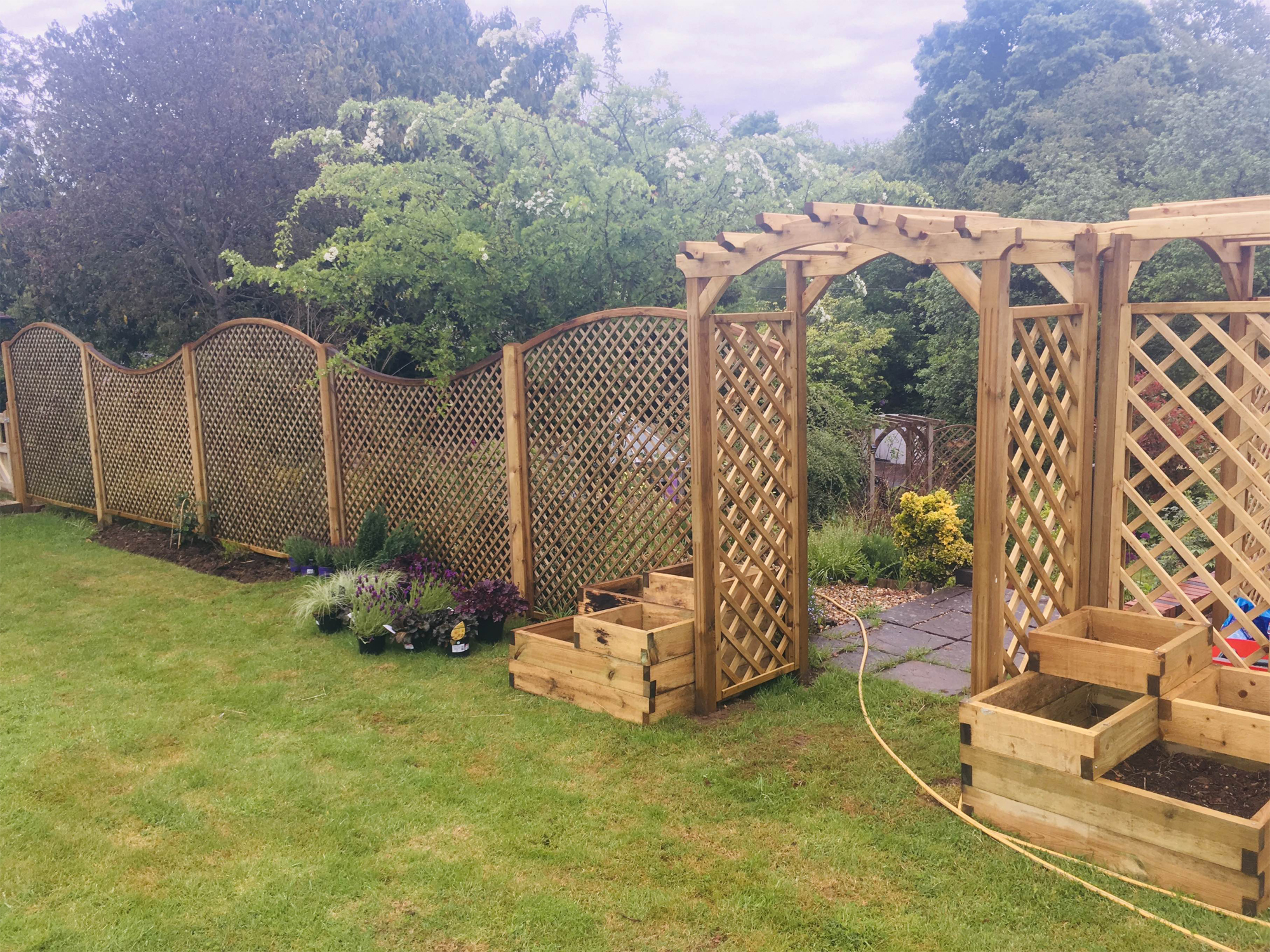 Wooden trellis, rose archway and raised beds by North Oaks Fencing in Hampshire